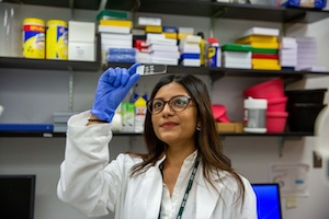 East Asian woman looking at sample slide