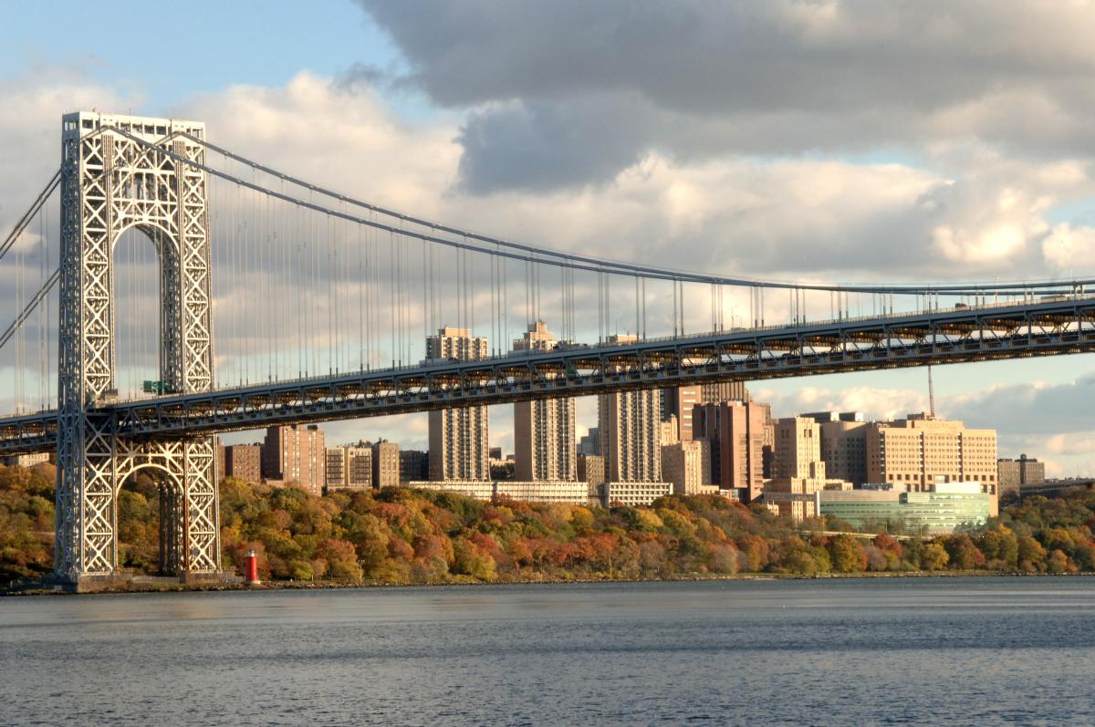 Photo of the George Washington bridge from the Jersey side in fall with Columbia University Medical Center in the background.